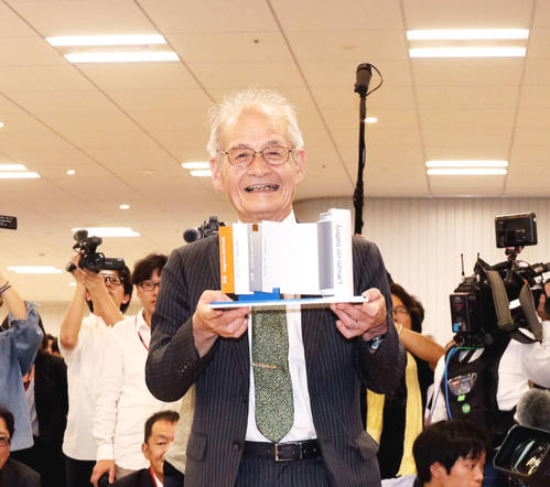 リチウムイオンバッテリーの模型を手に笑顔で写真に納まる「ノーベル化学賞」受賞の旭化成名誉フェローの吉野彰氏（撮影・河田真司）