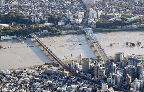 13日午前6時45分　台風19号の影響で水位が上がった多摩川。上は東京都大田区、下は川崎市中原区（共同）
