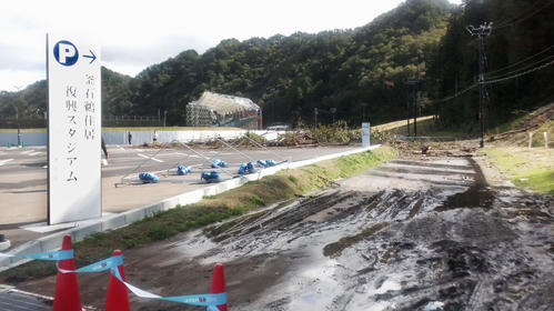 13日午前10時3分　ナミビア－カナダ戦が中止となった釜石鵜住居復興スタジアム。関係者駐車場に続く道路が土砂に覆われた