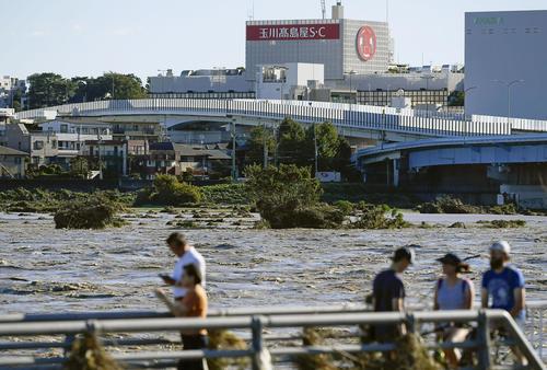 13日午前7時48分　台風19号による大雨で増水し濁流となった多摩川。手前側は神奈川県川崎市、対岸は東京都世田谷区（共同）