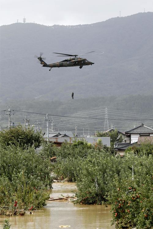 13日午後0時34分　台風19号による大雨で千曲川が決壊した長野市穂保で、ヘリコプターで救助される住民（共同）