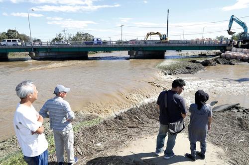 13日午後0時46分、栃木県佐野市赤坂町　秋山川の堤防が決壊し、市街地に流れ込む濁流（共同）