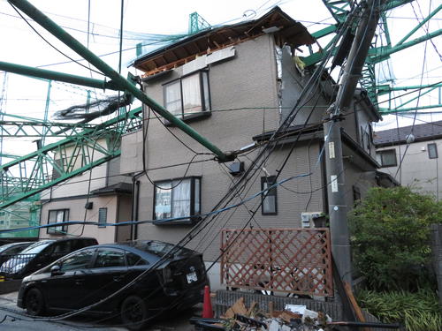 台風15号の影響で、ゴルフ練習場「市原ゴルフガーデン」のネットを支えていた鉄製の支柱2本が倒れ込んだ住宅（2019年9月10日撮影）