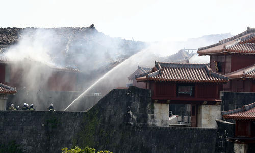 31日未明に出火し、懸命の消火活動が行われる首里城。中央部は焼け落ちた正殿（撮影・浅見桂子）