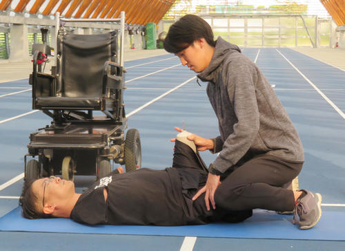 イベントに出席した作家の乙武洋匡氏は歩行前にストレッチを行う（撮影・佐藤勝亮）