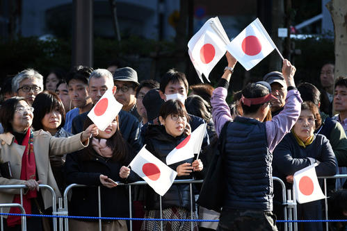 即位を祝うパレードで沿道の人々に日の丸の小旗が配られた＝港区・赤坂警察署前（撮影・滝沢徹郎）