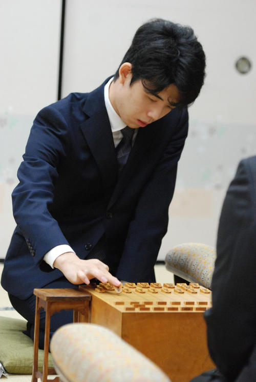 初手を指す藤井聡太七段（左）久保利明九段（撮影・松浦隆司）