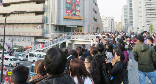 ローマ教皇を一目見ようと、東京メトロ後楽園駅前の歩道橋で待つ人々（撮影・佐藤勝亮）