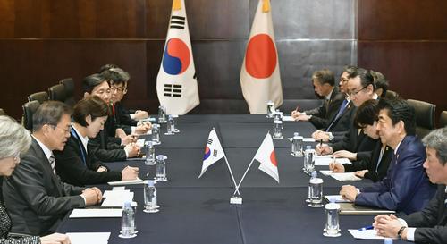韓国の文在寅大統領（左から2人目）と会談する安倍首相（共同）