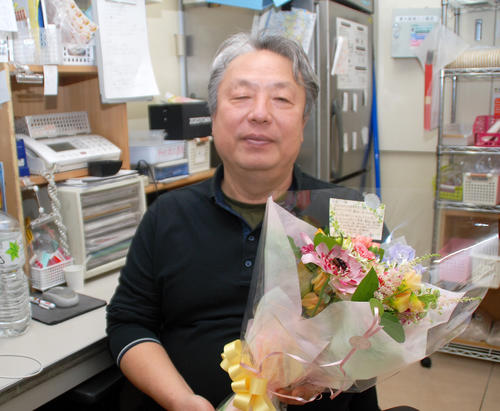 来店した大阪府内のコンビニ店オーナーから感謝の花束を受け取った松本実敏さん（撮影・松浦隆司）
