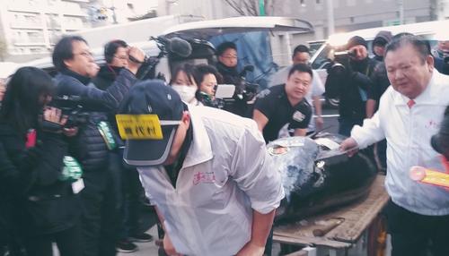 報道陣のフラッシュの中、276キロのホンマグロが木村社長とともに築地場外市場に入ってきた