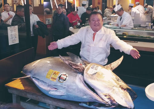 競り落としたマグロとざんまいポーズをとる木村社長