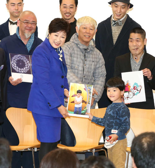 写真家ホンマタカシさん（中央）の作品のモデルになった子どもを壇上に呼び、写真に納まる小池百合子都知事（撮影・丹羽敏通）