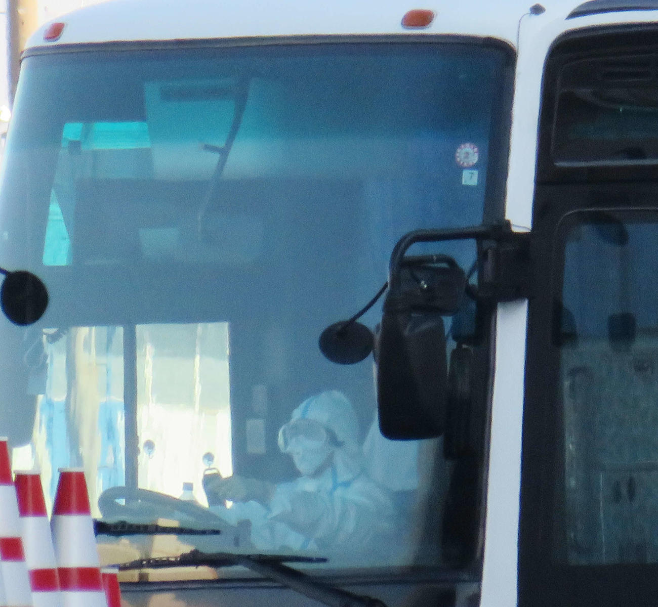 ダイヤモンド・プリンセスから感染者を乗せたと見られるバスを運転する、防護服姿の運転手（撮影・村上幸将）