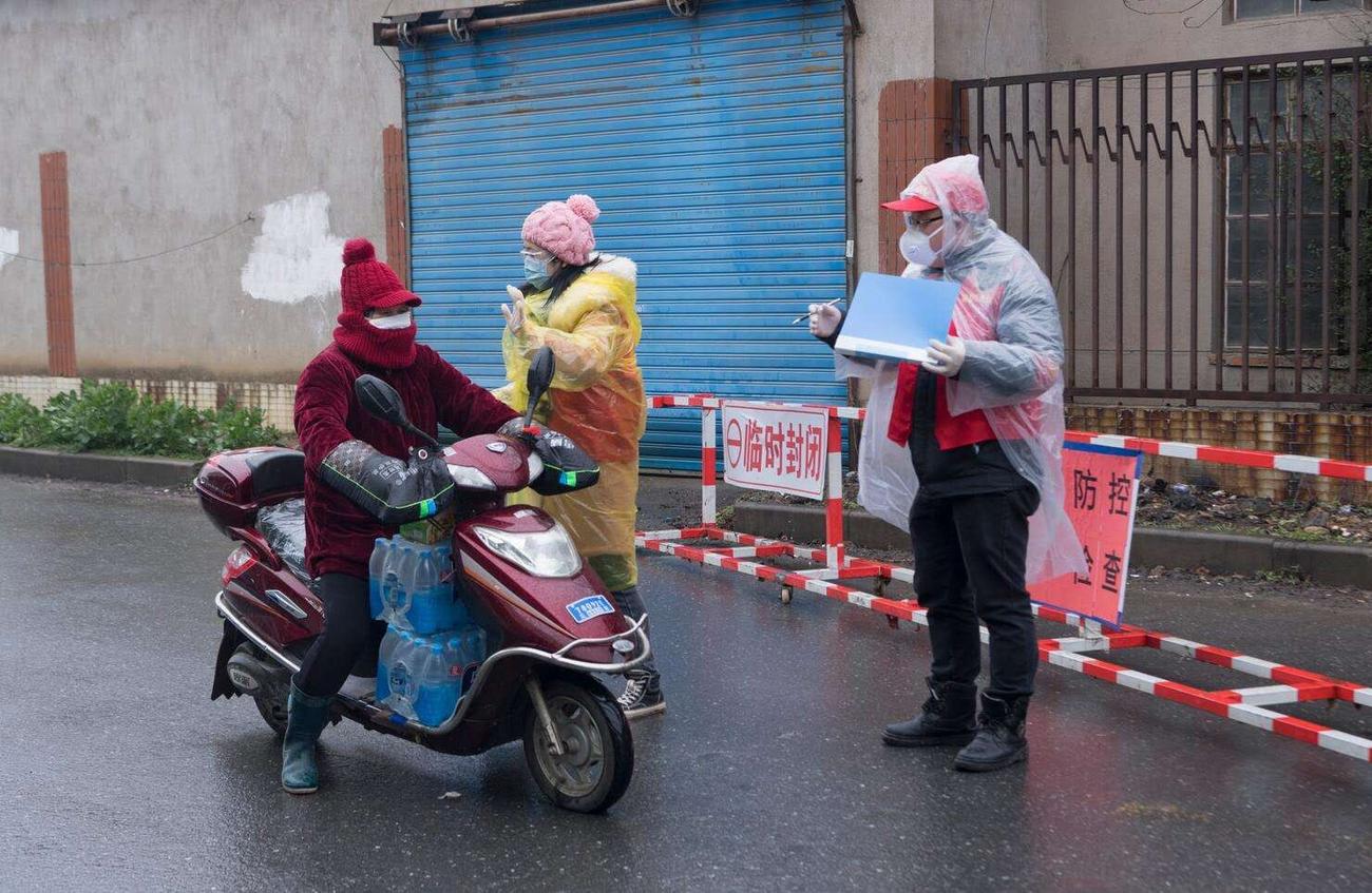 江蘇省無錫市でバイクで走行する人に聞き取りをする担当者（関係者提供）