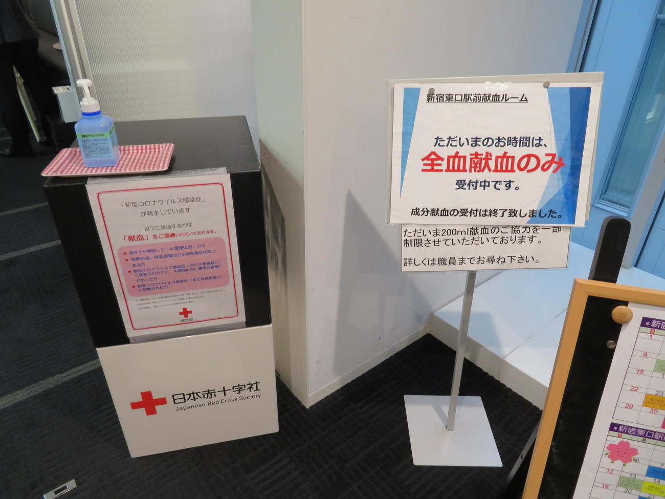 新宿東口駅前献血ルームの入り口に置かれた消毒液と注意書（撮影・村上幸将）