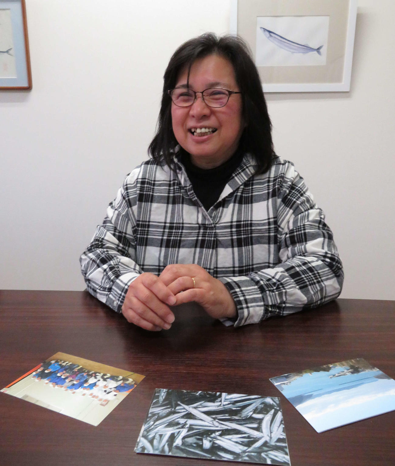 記念撮影した写真を見せながら、従業員がいい笑顔をしていると語るワイケイ水産取締役の木村悦子さん（撮影・近藤由美子）