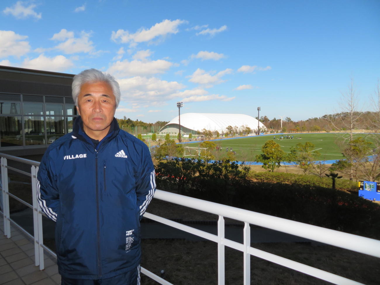 東京五輪聖火リレーのグランドスタート地点を背に、復興への思いを語るJヴィレッジ上田栄治副社長（撮影・村上幸将）