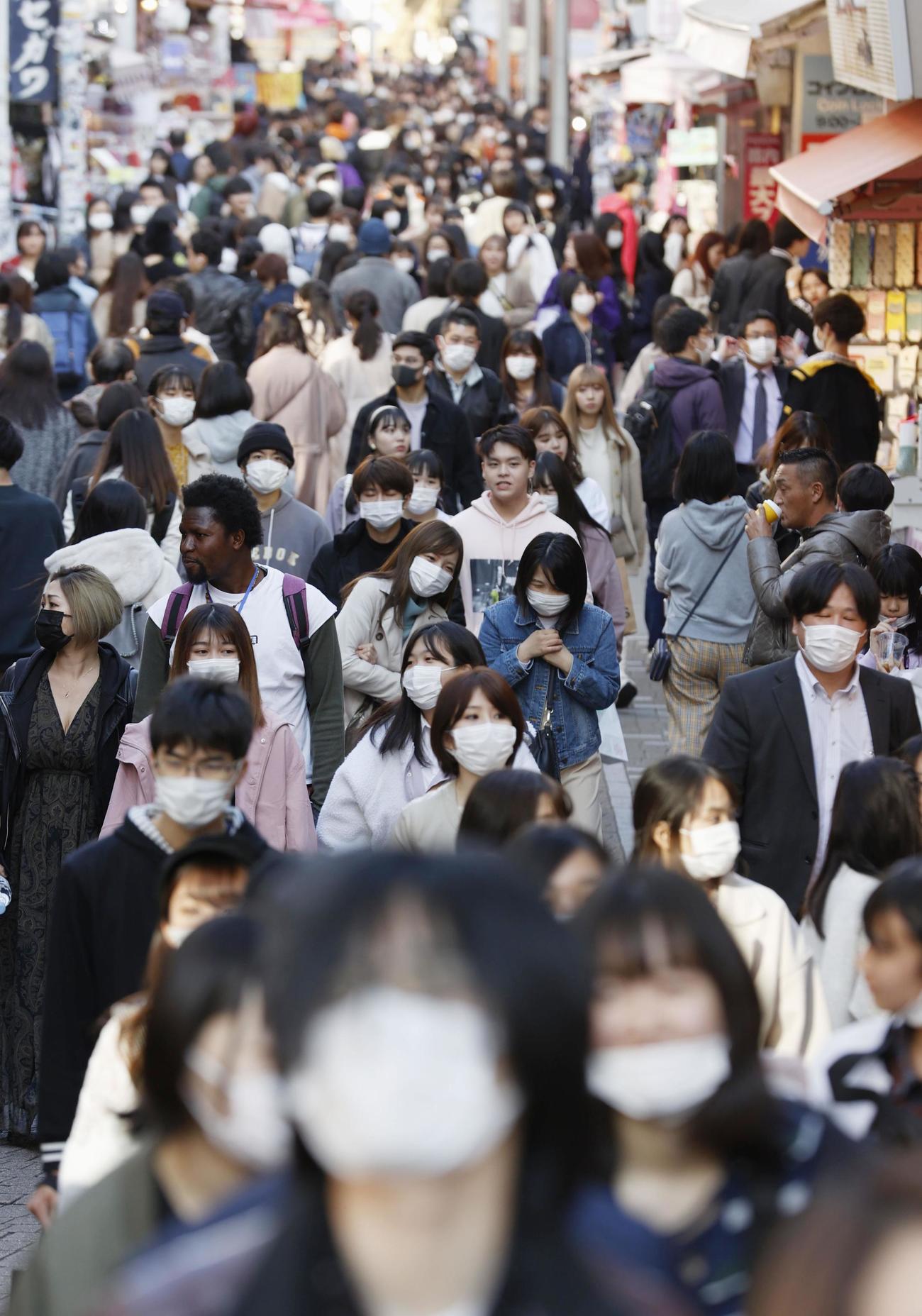 25日、東京・原宿の竹下通りをマスクを着けて歩く大勢の人たち(共同)