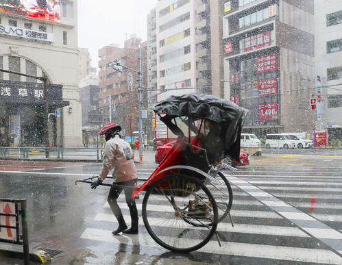 不要不急の外出自粛の週末に雪が降り、閑散とする浅草駅の前を走る人力車（撮影・河田真司）