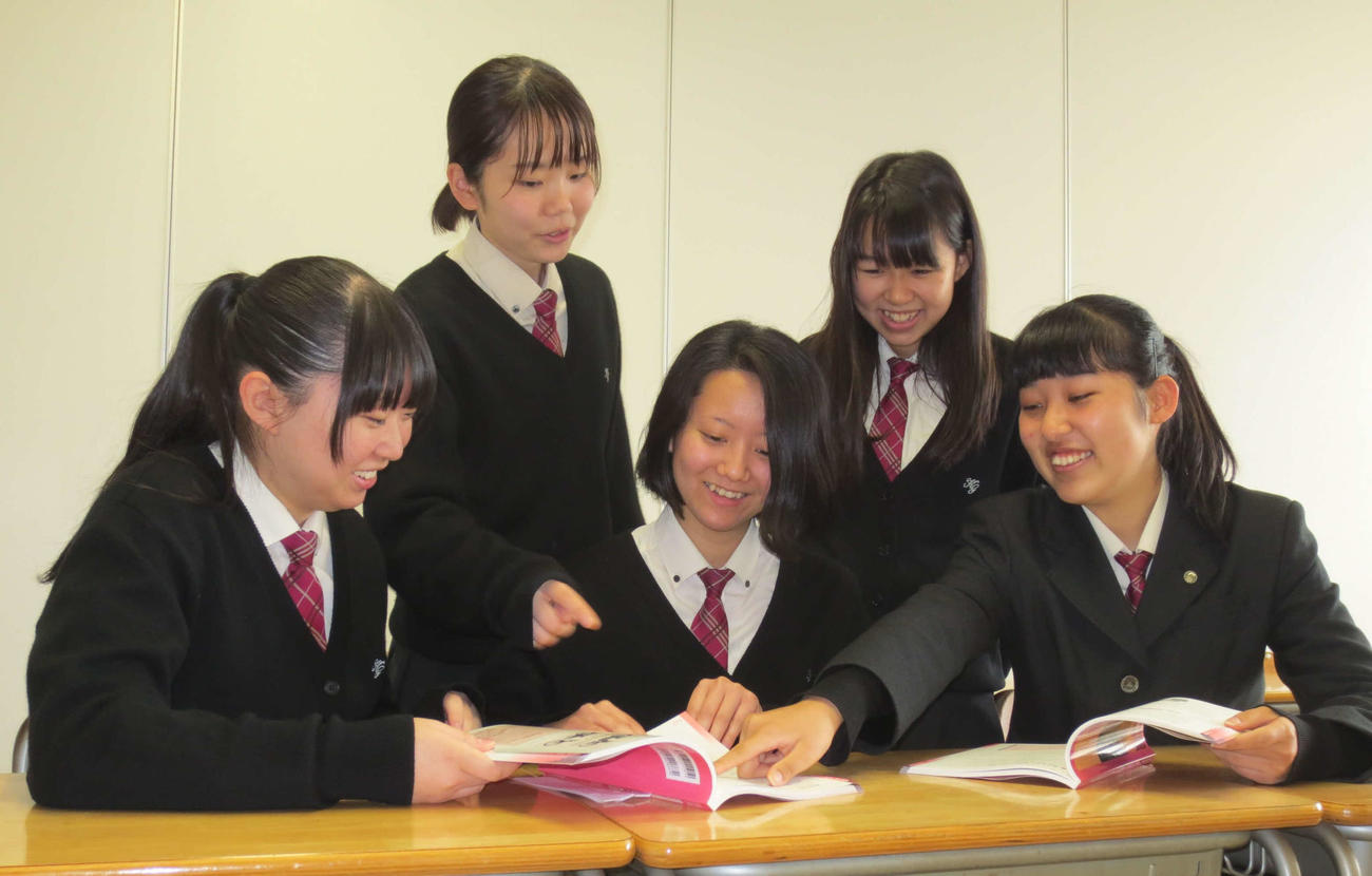 知的財産授業で使う本を見る寺田梨乃さん（前列右端）ら5人組