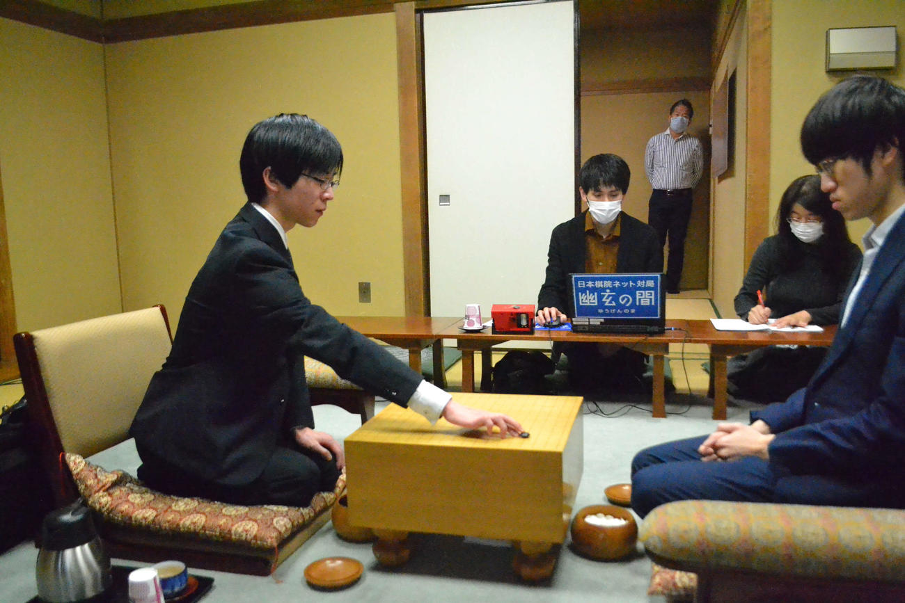 第75期本因坊戦プレーオフで初手を打つ芝野虎丸名人（左）。右は対戦相手の許家元八段
