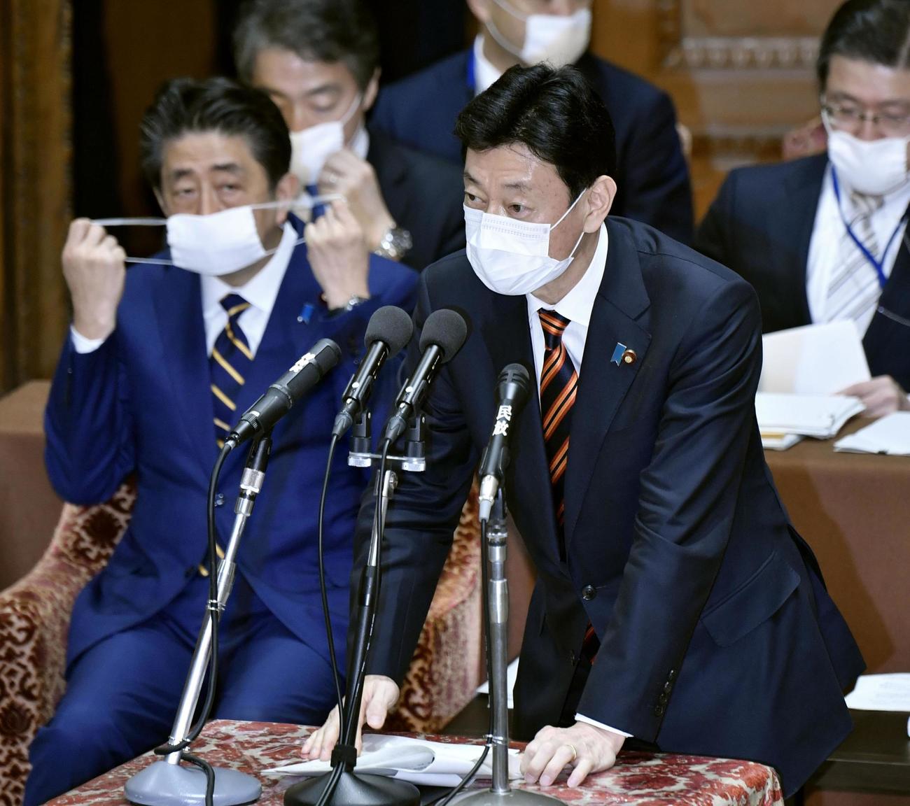 衆院議運委で答弁する西村経済再生相。左は安倍首相（共同）