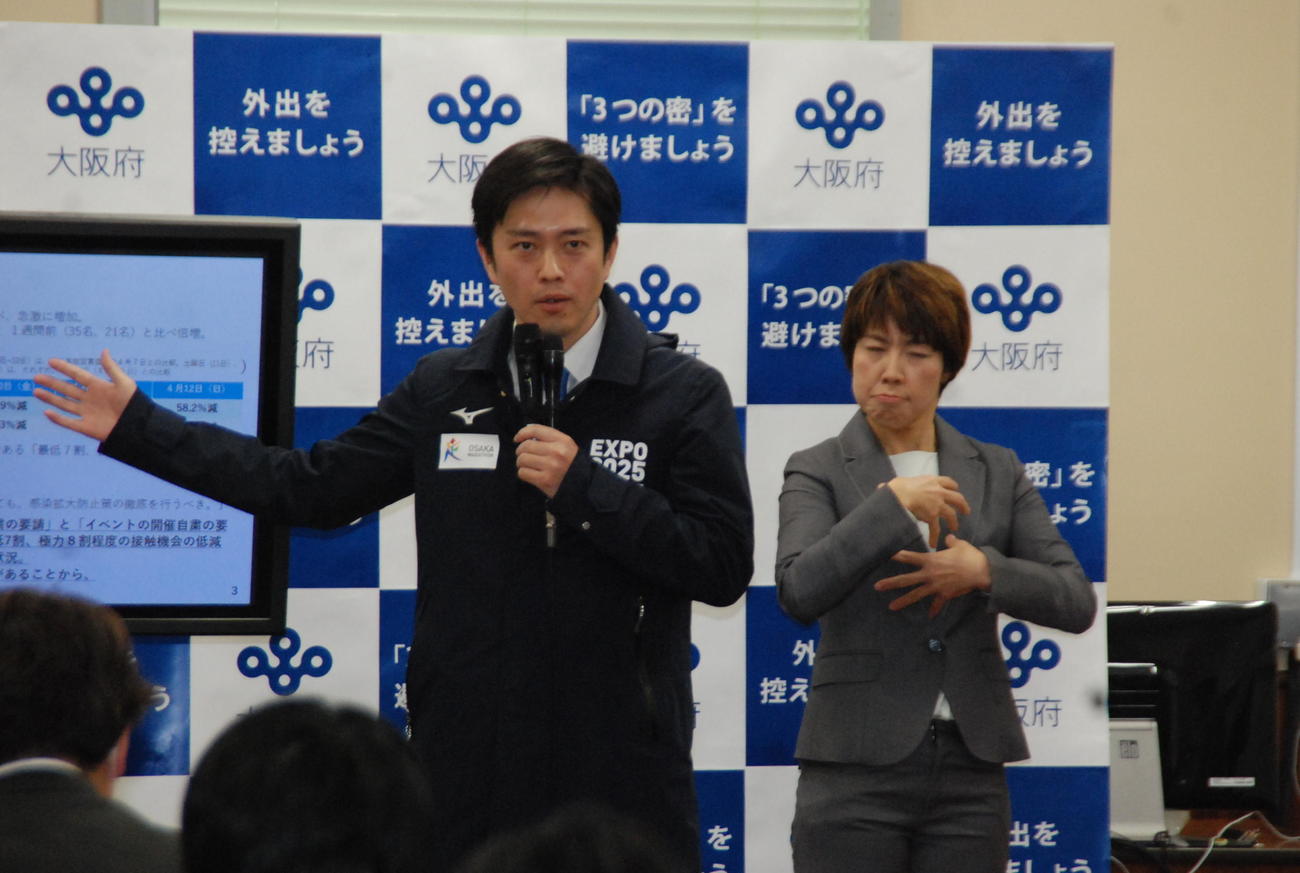 大阪府庁で手話通訳者（右）とともに会見する大阪府の吉村洋文知事（撮影・松浦隆司）