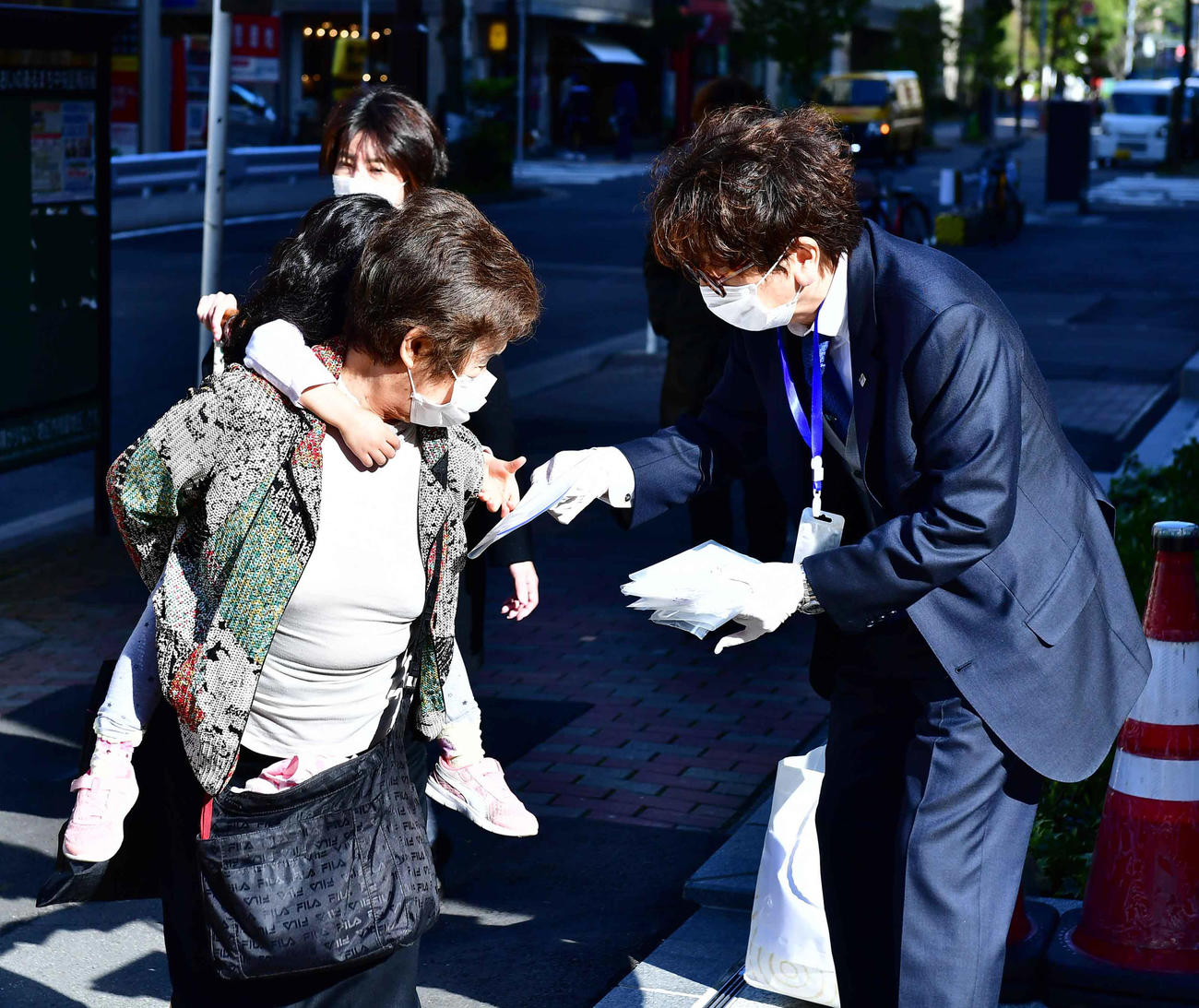 ボランティアで通行人にマスクを配る東京・築地にある地元不動産会社の関係者（撮影・小沢裕）　