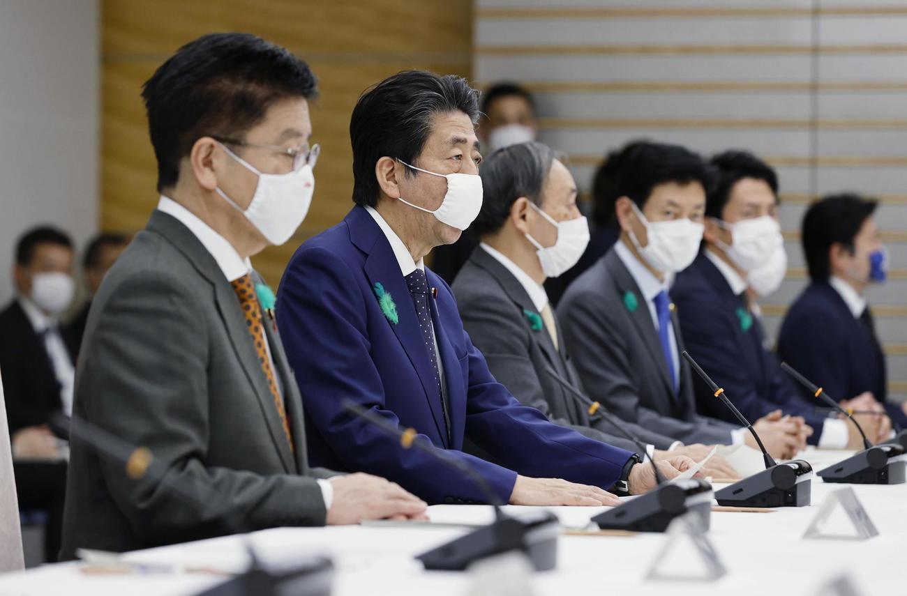 新型コロナウイルス感染症対策本部の会合で、全都道府県に緊急事態を宣言する安倍首相（左から2人目）（共同）