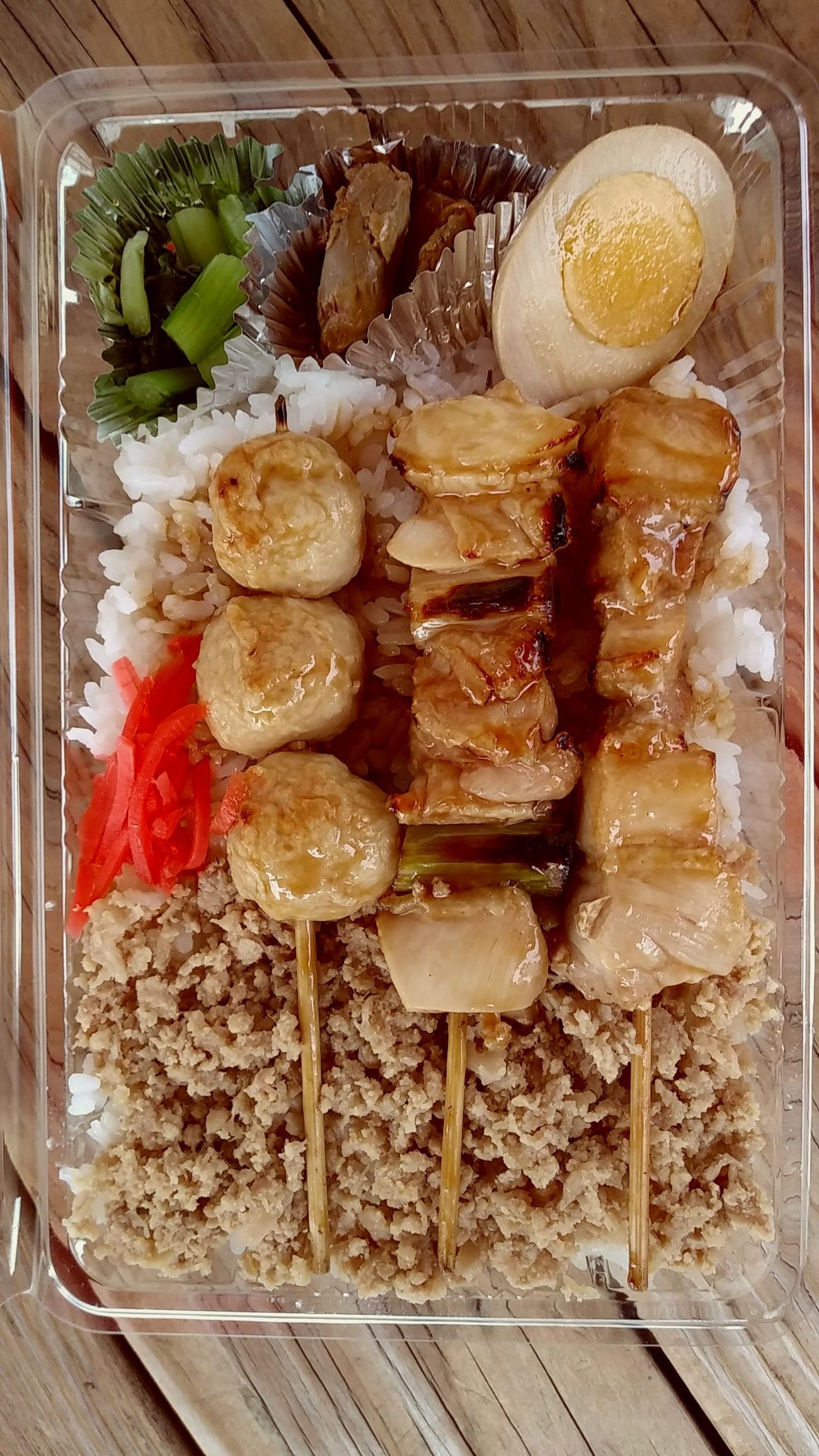 鳥藤ワンコインのやきとり弁当。串は左からつくね、ネギマ、ひなどり。そぼろがご飯の上に乗っかって、付け合わせで煮玉子、鶏レバー煮、青菜の漬物と豪華満点