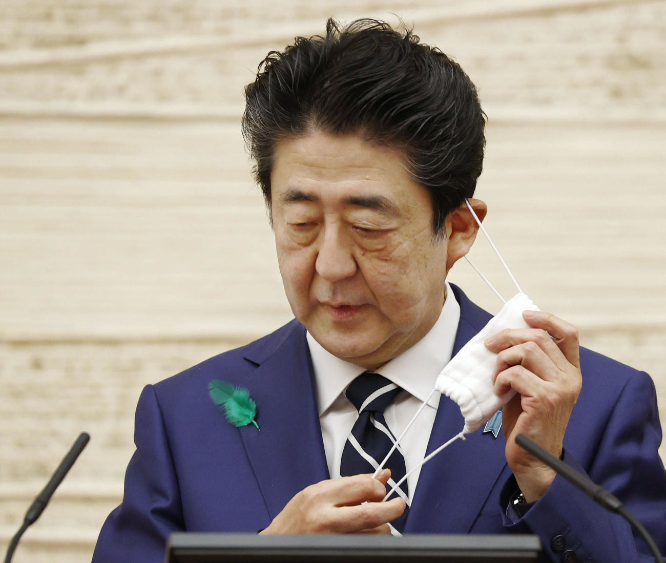 記者会見前にマスクを外す安倍首相（共同）