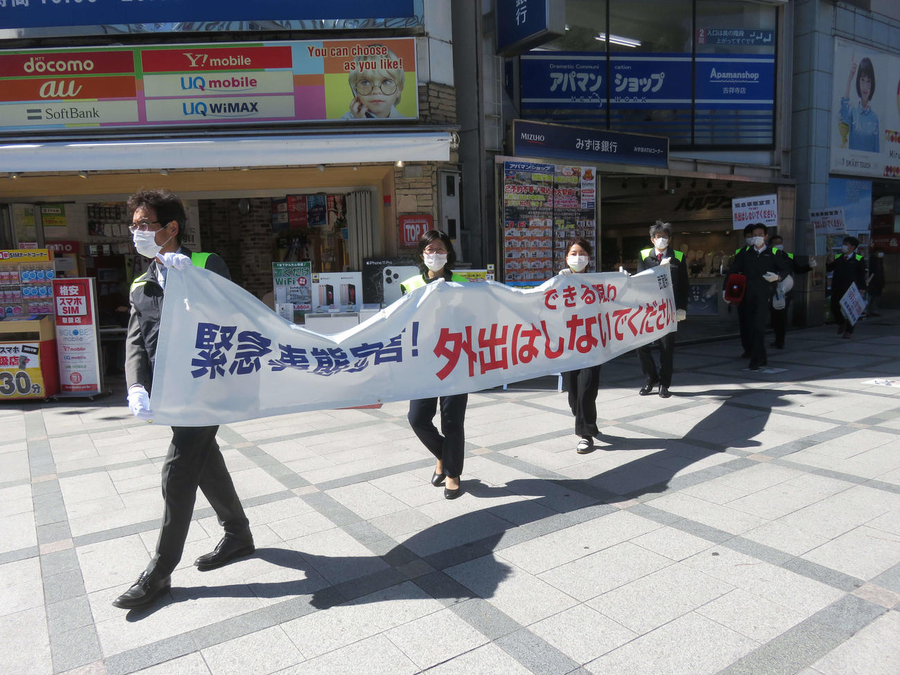 吉祥寺のアーケード街などで武蔵野市の職員らが外出自粛を求める横断幕を手に注意喚起した（撮影・大上悟）