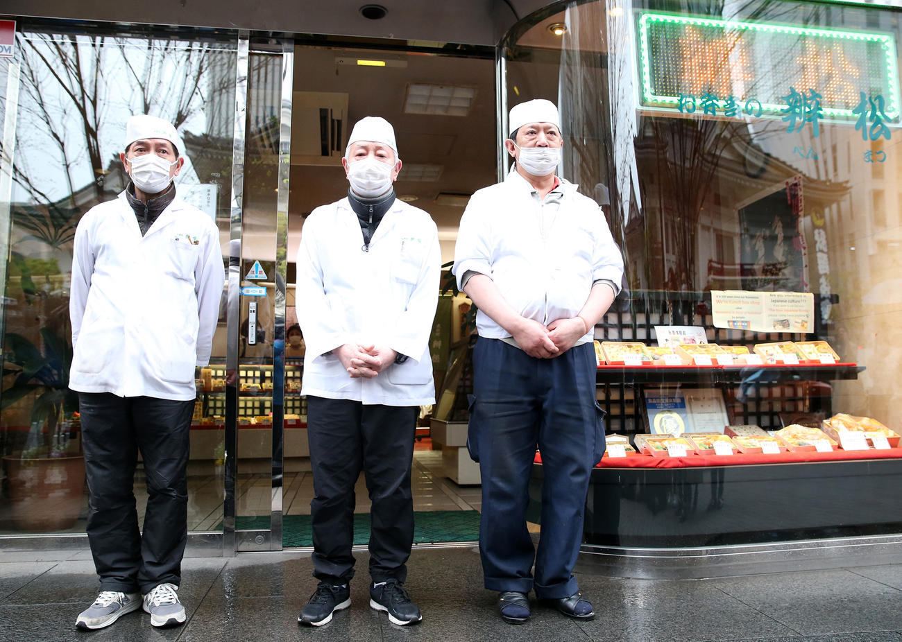 店舗の前で閉店のあいさつをする「木挽町辨松（こびきちょうべんまつ）」の猪飼信夫社長（中央）。左は弟の猪飼克二郎さん、右は小島健資専務（撮影・河野匠）