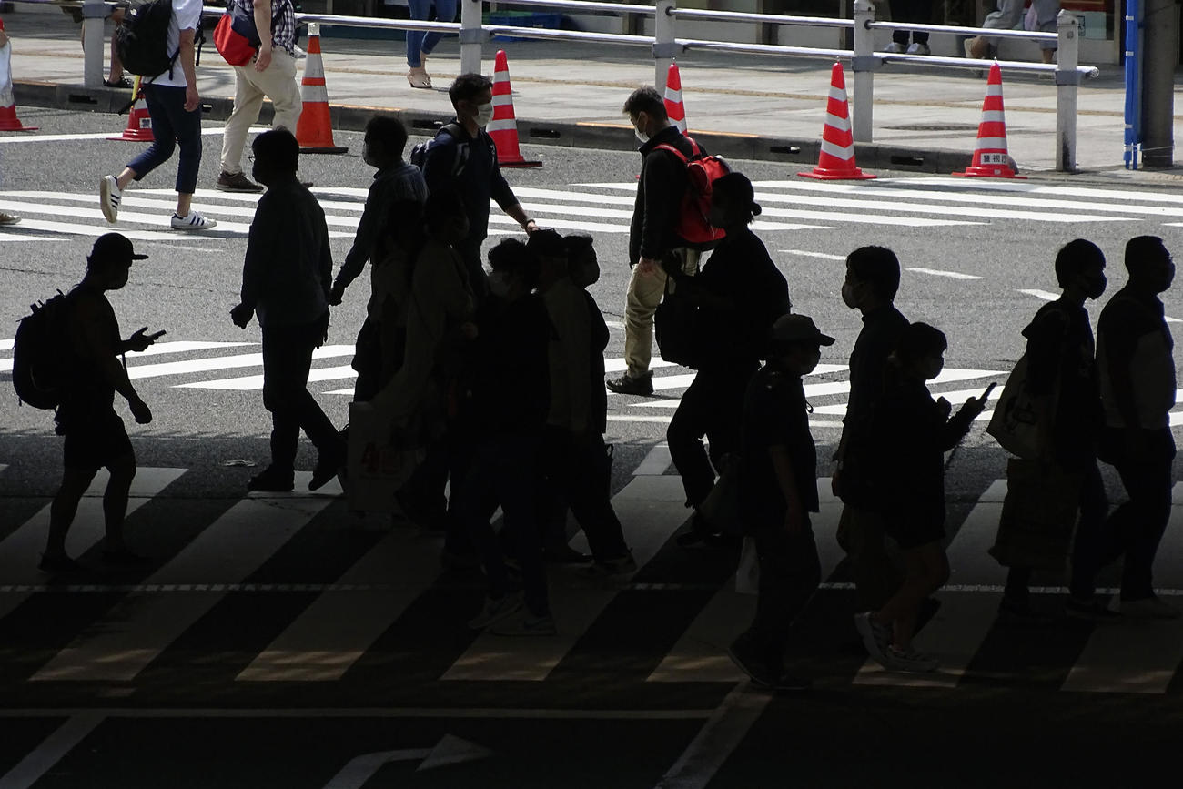 緊急事態宣言が延長された翌日の5日、町を歩く人々（AP）