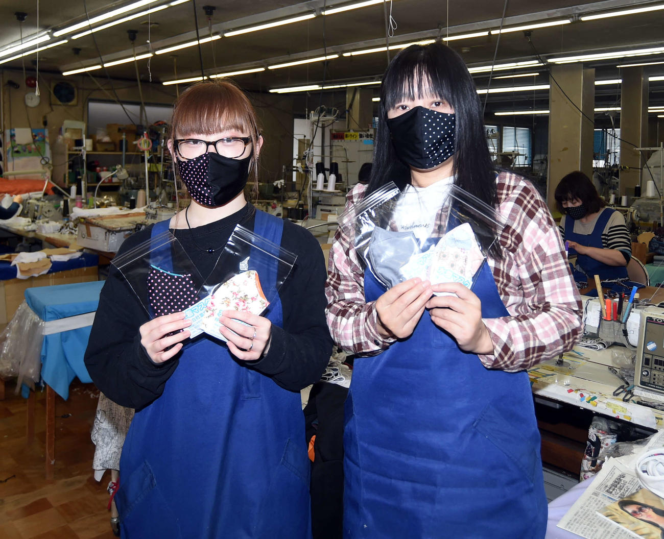 完成した水着マスクを見せる富樫縫製の従業員たち