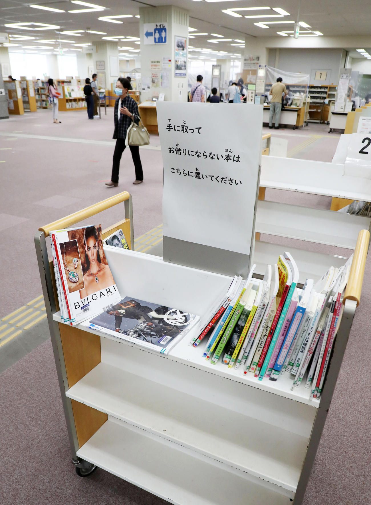 一度手に取った本は棚に戻さず特設のワゴンへ戻しウイルスが消えるまで管理する（撮影・加藤哉）