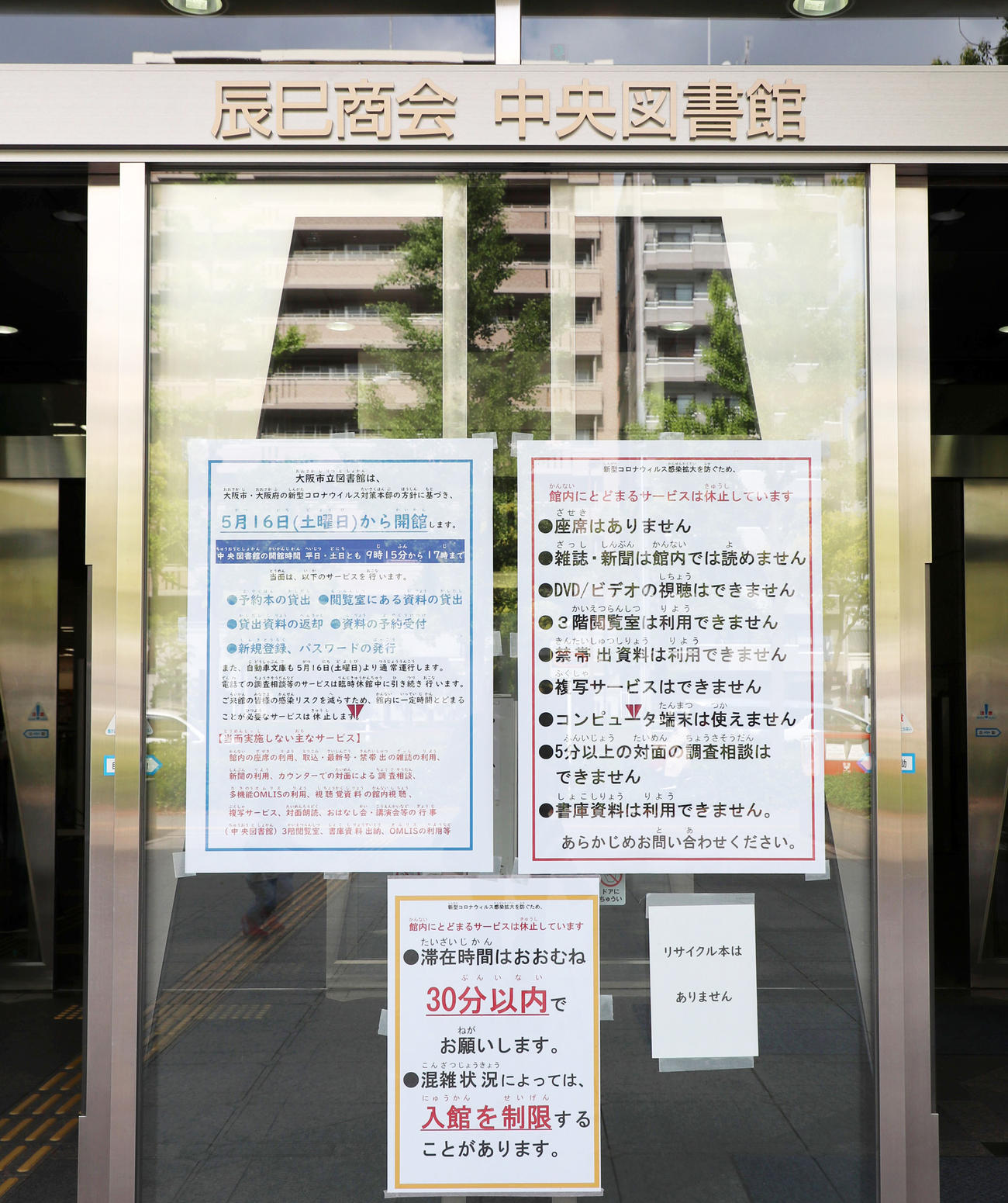 大阪市立中央図書館の入り口には16日からの開館とともに滞在時間30分以内など、コロナ対策の案内がかかれている（撮影・加藤哉）