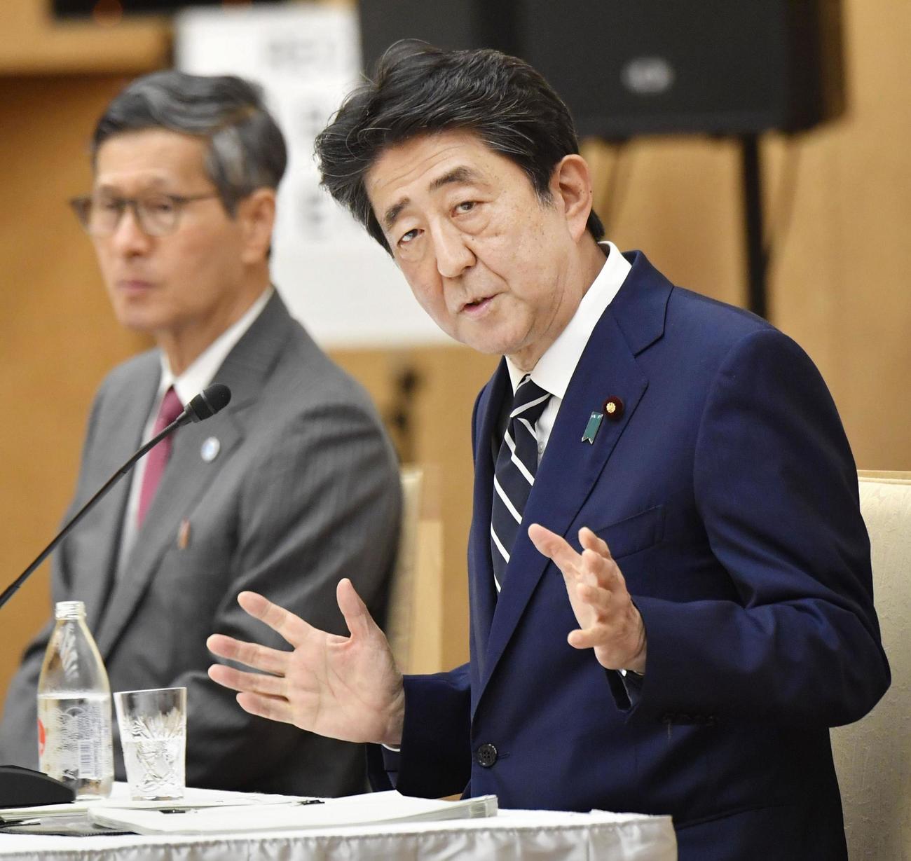 新型コロナウイルス特措法に基づく緊急事態宣言全面解除について記者会見する安倍首相（右）（共同）