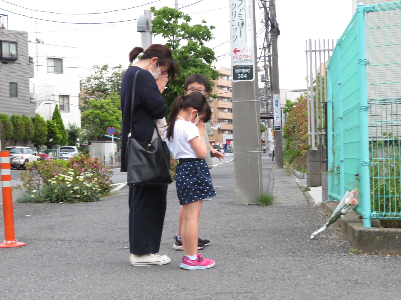 スクールバスを待っていた私立カリタス小の児童ら20人が殺傷された事件現場。事件から1年を迎えた28日、花やお菓子を供えたり、祈る人の姿が絶えなかった（撮影・近藤由美子）