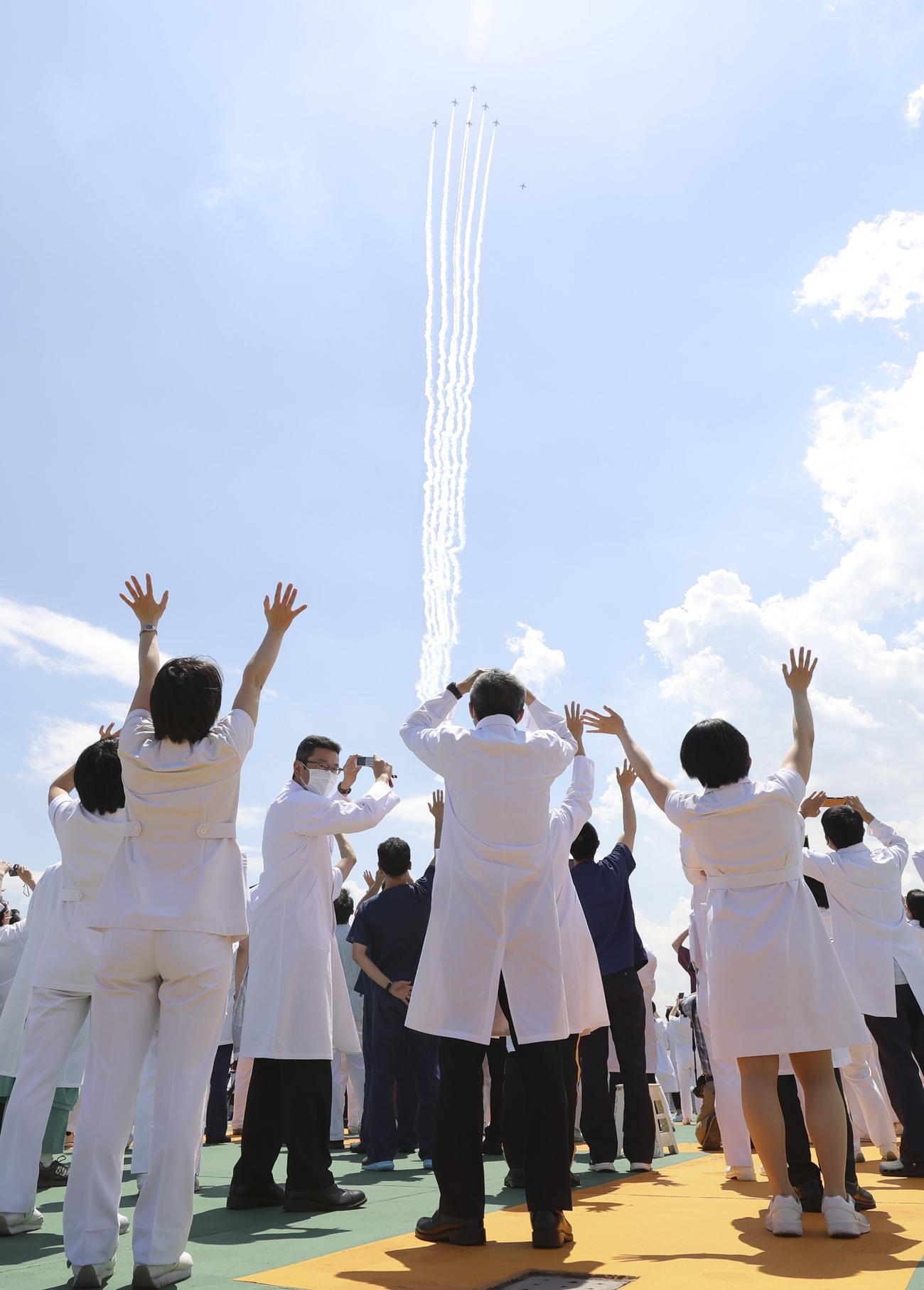 医療従事者に敬意を示すため、自衛隊中央病院の上空を飛行するブルーインパルス＝29日午後、東京都世田谷区（共同）