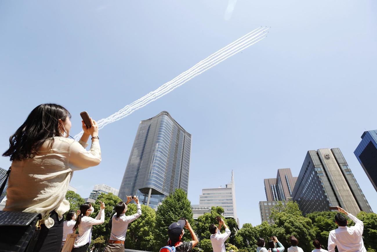 医療従事者に敬意を示すため、東京都心上空を飛行する航空自衛隊のブルーインパルス・日比谷公園で撮影（共同）
