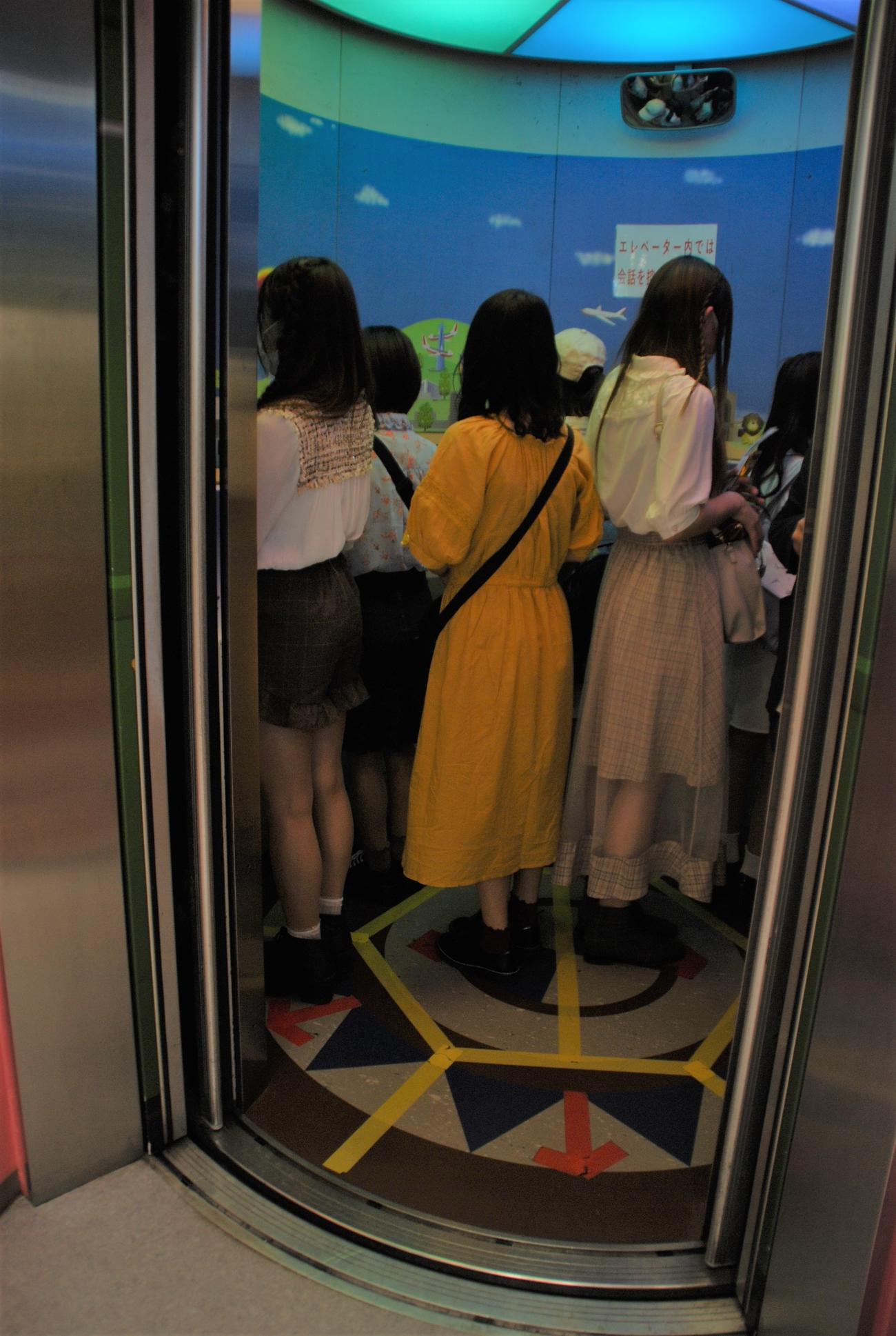 展望台へのエレベーターの床には「→」が記入され、来館者は外側に向いて利用（撮影・松浦隆司）
