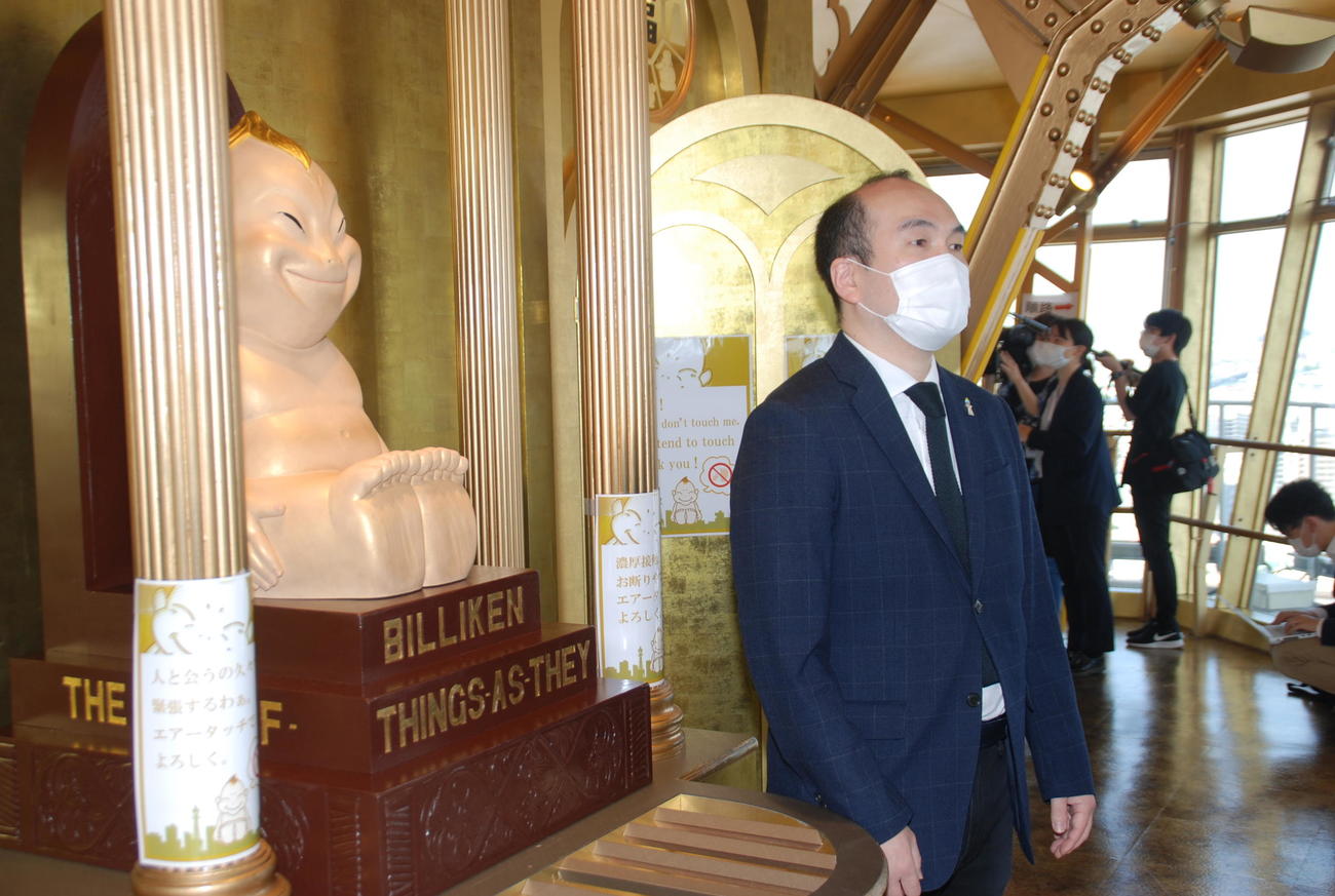 ビリケンさんの前でインタビューを受ける運営会社「通天閣観光」の高井隆光社長（撮影・松浦隆司）