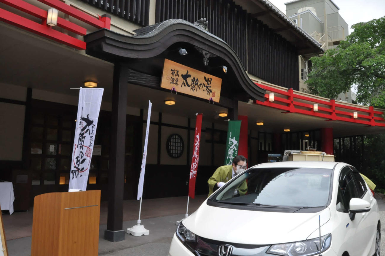 ドライブスルーで温泉を販売する従業員（有馬温泉太閤の湯提供）