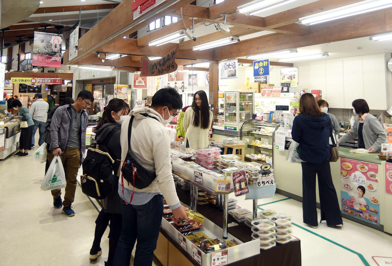 道の駅内の売店で買い物を楽しむ観光客