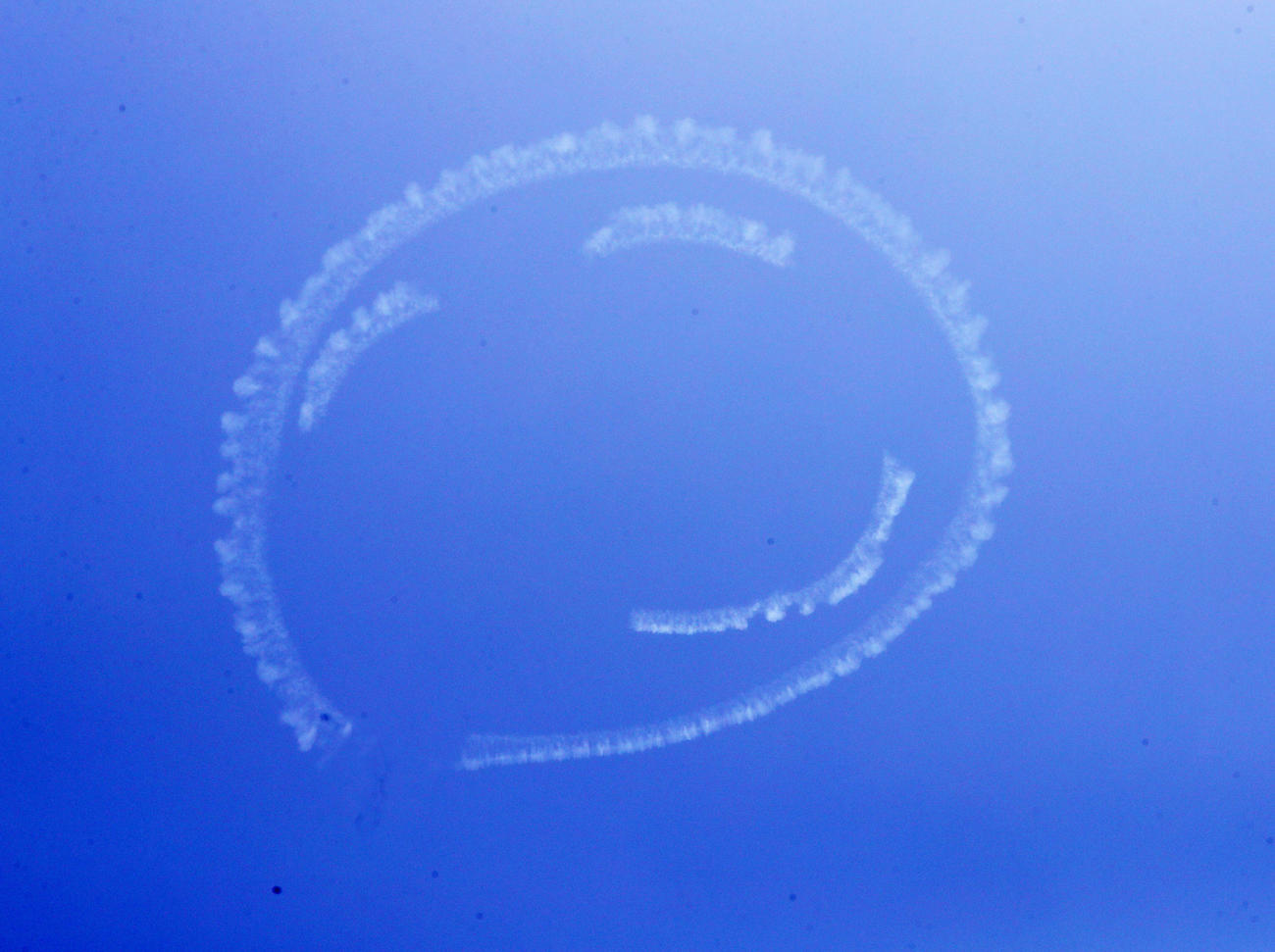 エアロバティックパイロットの室屋義秀さんが、福島の青空に描いたにこちゃんマーク。「Fly　for　ALL　♯大空を見上げよう」フライトが、浜通り地方の小名浜から飯舘村まで行われた（撮影・野上伸悟）