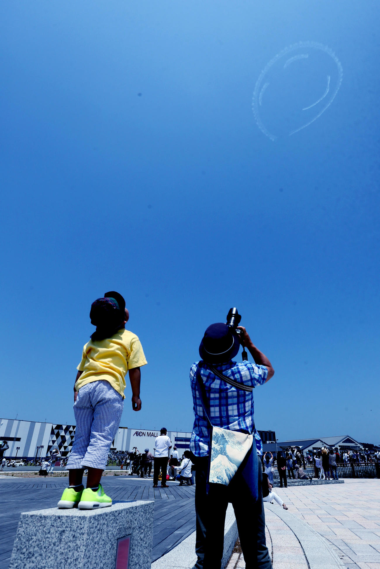エアロバティックパイロットの室屋義秀さんが、福島の青空ににこちゃんマークを描いた。「Fly　for　ALL　♯大空を見上げよう」フライトが、浜通り地方の小名浜から飯舘村まで行われた（12時10分、いわき市小名浜で）（撮影・野上伸悟）