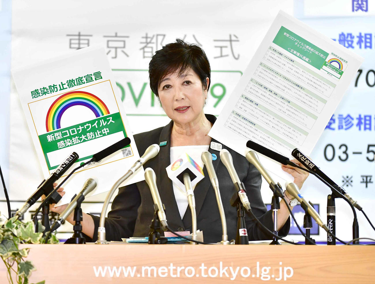 定例会見でボードを掲げながら新型コロナウイルス感染拡大防止を訴える小池東京都知事（撮影・小沢裕）