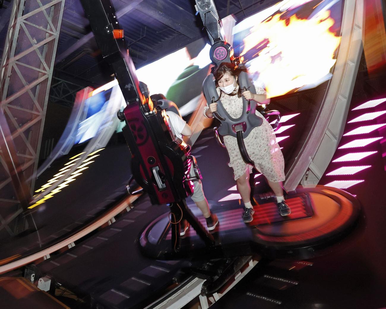 営業を再開した「東京ジョイポリス」で、アトラクションを楽しむマスク姿の人たち（共同）